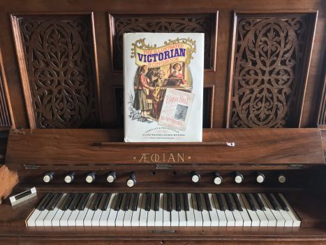 The Illustrated Victorian Songbook is placed on the music rest of an Aeolian organ.