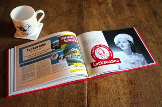 Logomotive open beside a mug of coffee, displaying a double-page spread on the Lackawanna Railroad and its fictional heroine Phoebe Snow. 