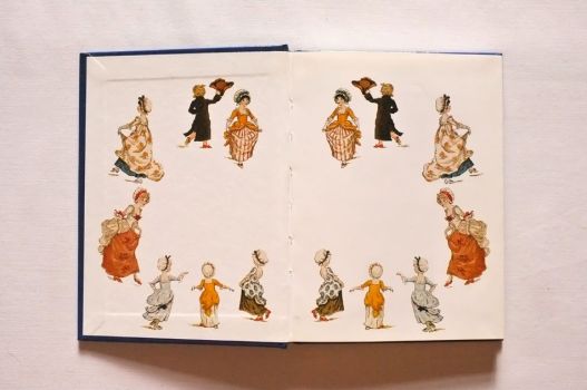 The front endpaper of The Kate Greenaway Address Book is bordered with colour illustrations of a family dancing.