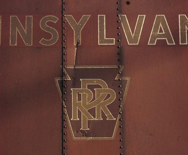 In a colour photograph taken by Ian Logan in the 1970s, the keystone logo of the Pennsylvania Railroad survives on the side of a freight wagon years after the company ceased to exist.