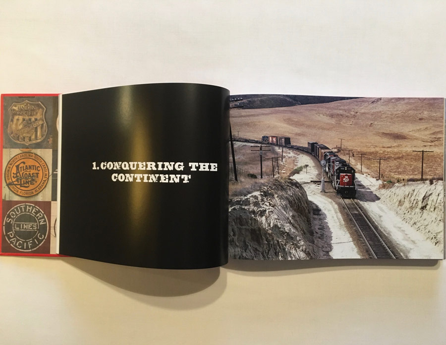 In this colour photograph taken in the 1970s by Ian Logan, author of Logomotive, a Southern Pacific GP 30 diesel locomotive draws a long train of boxcars and flat cars up a pass in the New Mexico desert, with two additional locomotives providing power immediately behind. and telegraph poles following the track. The company’s SP logo is picked out in white against the company’s ‘bloody nose’ livery.