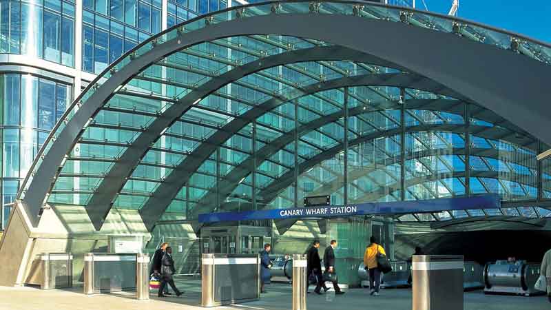 The arched, glazed roof of Canary Wharf Station in London provides an airy canopy for the escalators leading down to the platforms.