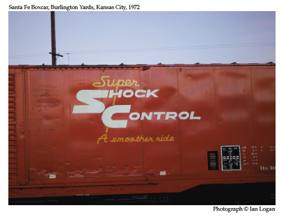 In this colour photograph taken by the railfan designer Ian Logan in 1972, the side of a brown Santa Fe boxcar carries the legend Shock Control in bold white capitals and the slogan A smoother ride in a light-yellow script face. 