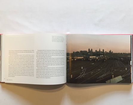 In this atmospheric colour photograph taken from a control tower in the 1970s, the silvery tracks of the Burlington Northern freight yards in Kansas City stretch away to the city skyline, lines of stationary boxcars picked out by a slanting sun. 
